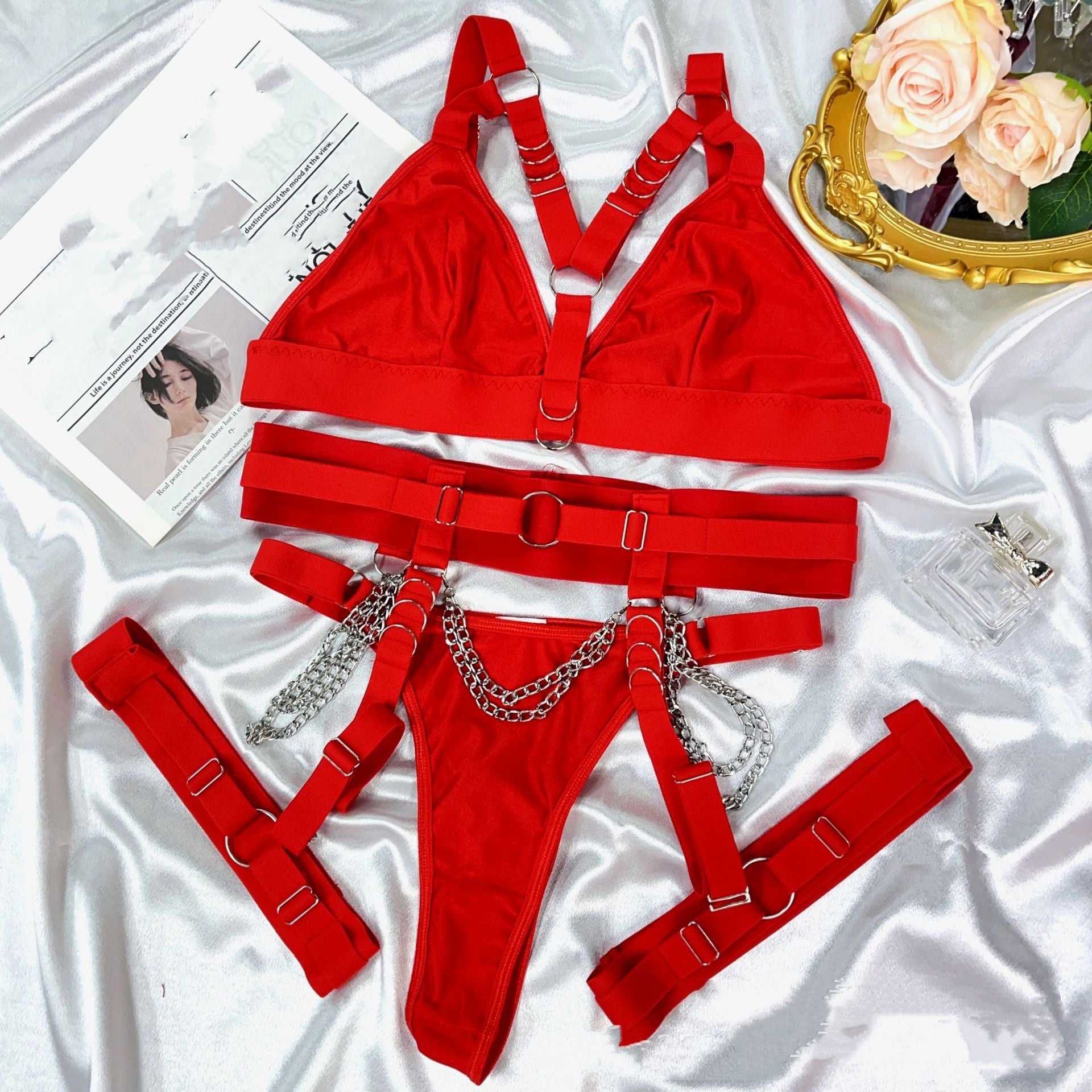 Sexy and alluring lingerie set with straps, metal chains, thong, and thigh-high stockings.